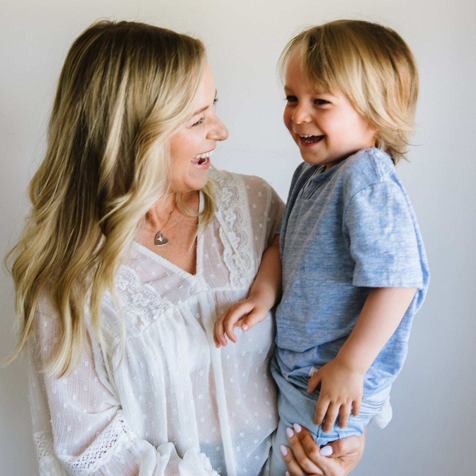 Woman laughing with child wearing handmade custom sound wave heart necklace