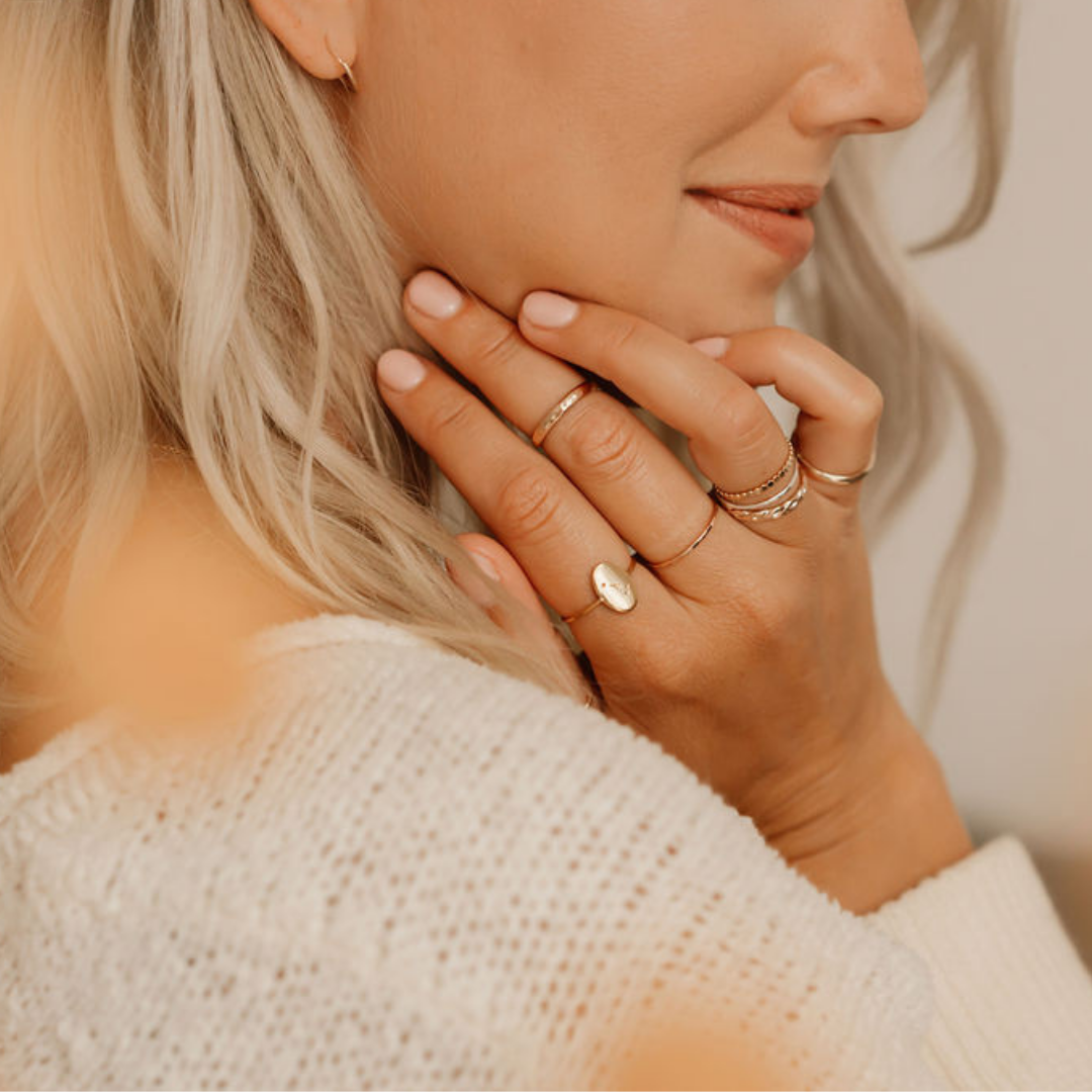 Model wearing minimal rings stacked and layered