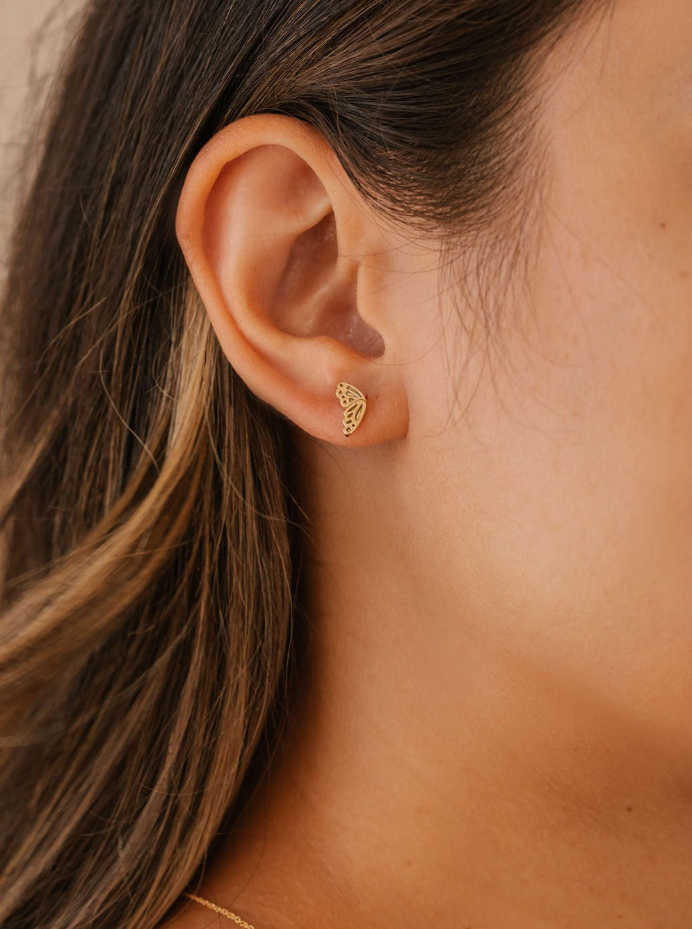 she is wearing butterfly wing stud earrings made in Canada