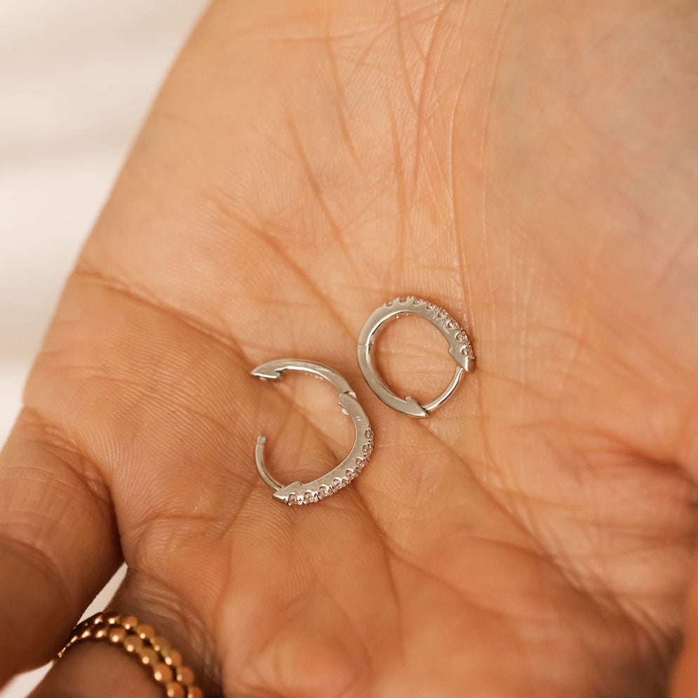 Silver pave hoop earrings on a palm