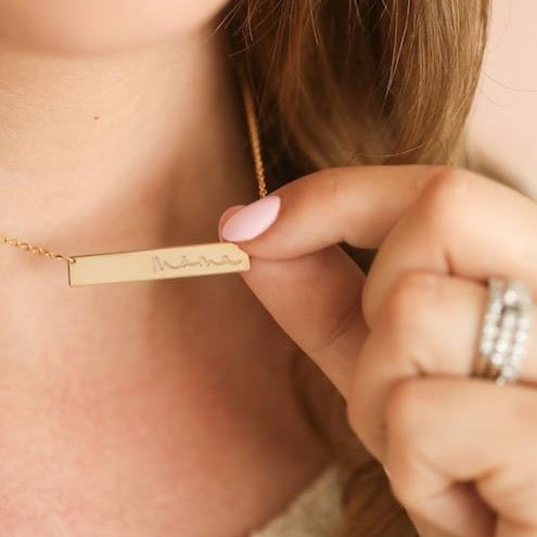 Woman wearing gold handmade custom handwriting bar necklace
