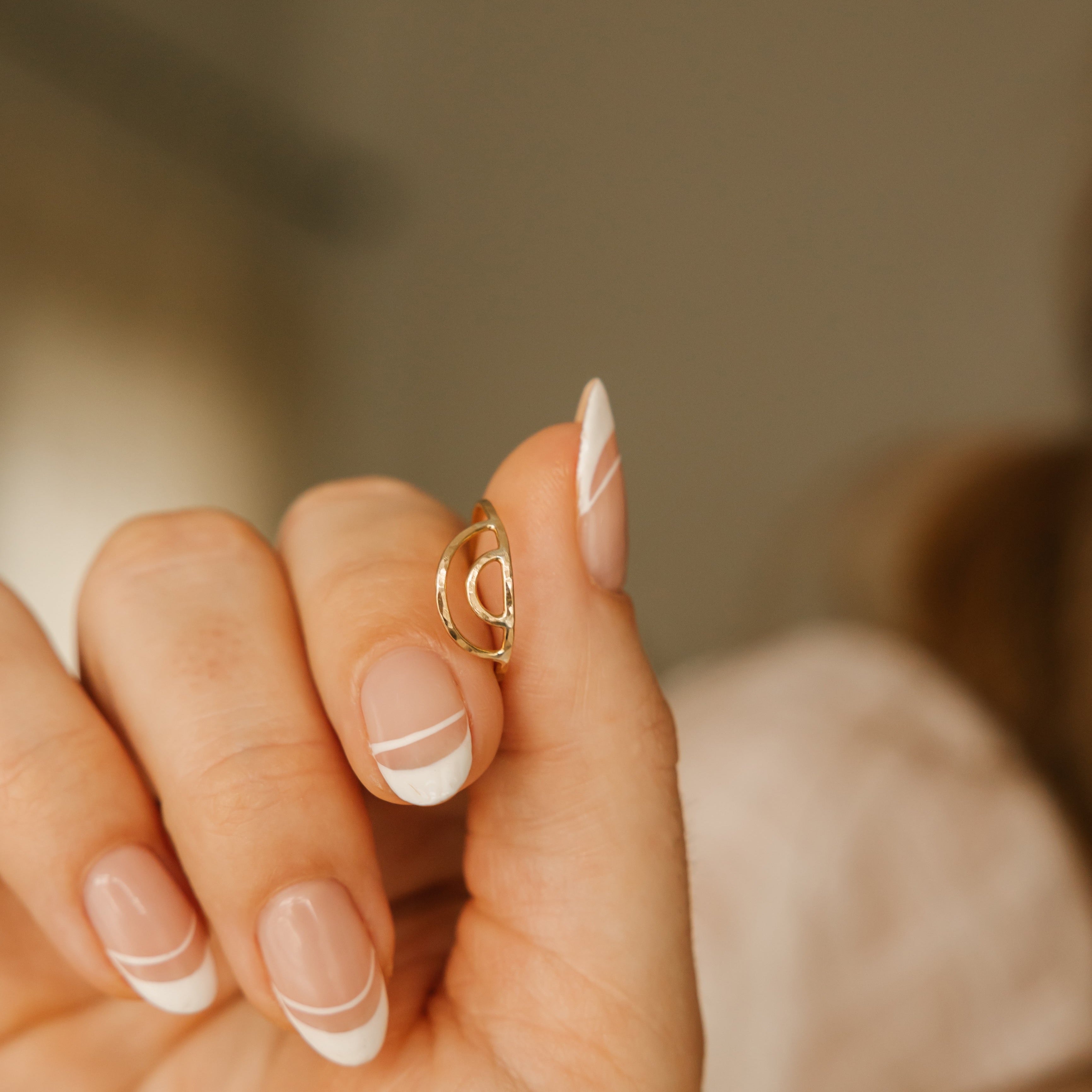 a women is wearing a gold filled rainbow ring.