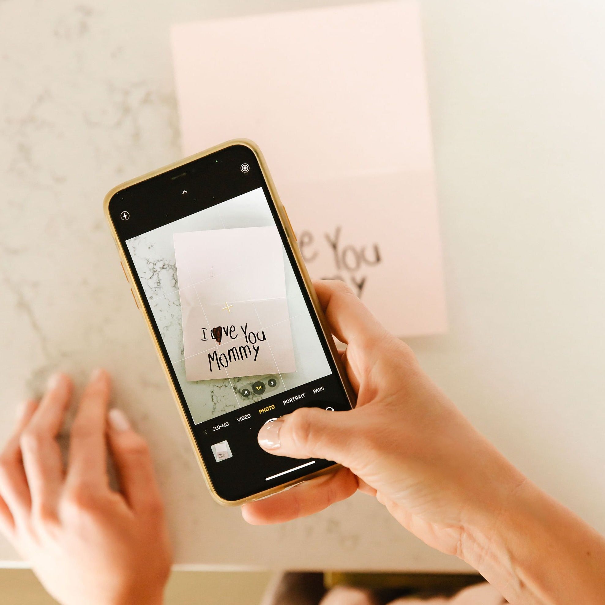 a woman is taking a photo of the handwriting by her iphone. 