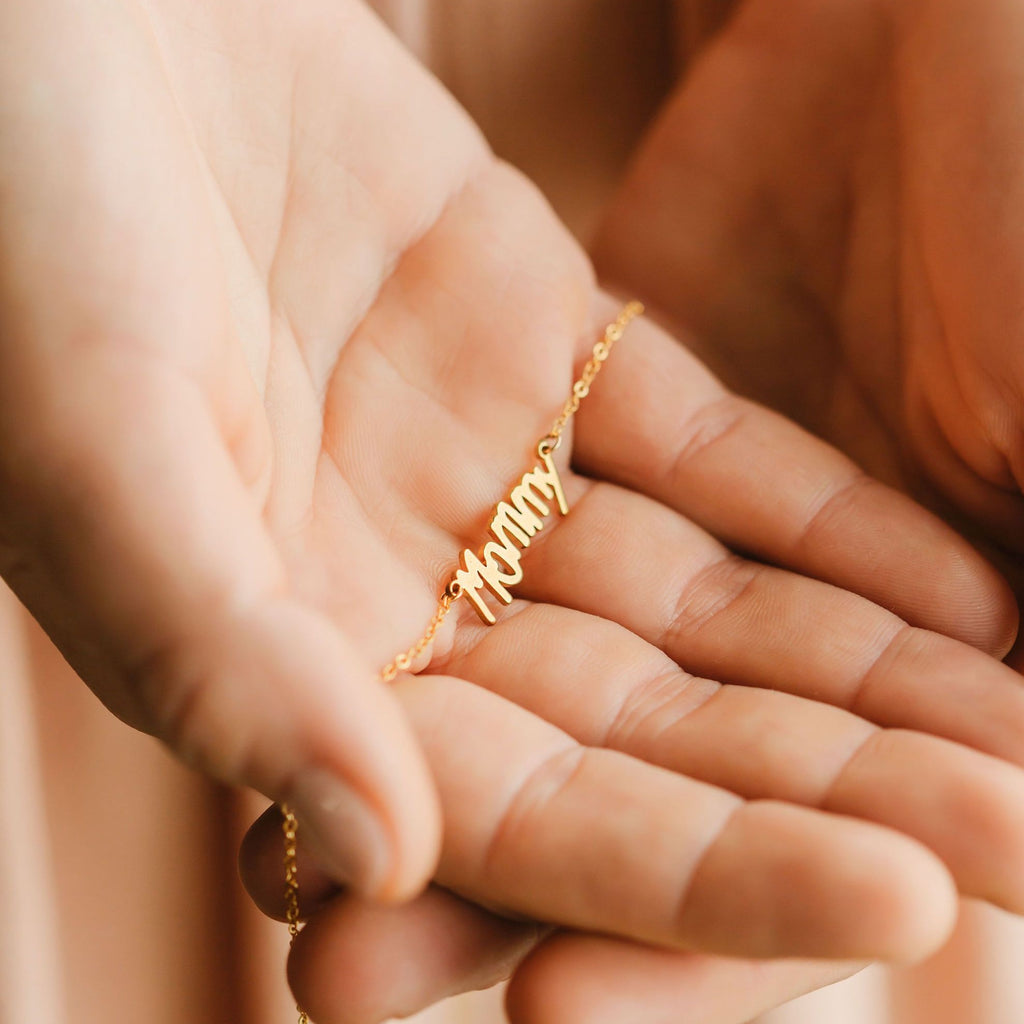 a woman is holding the name signature pendant 