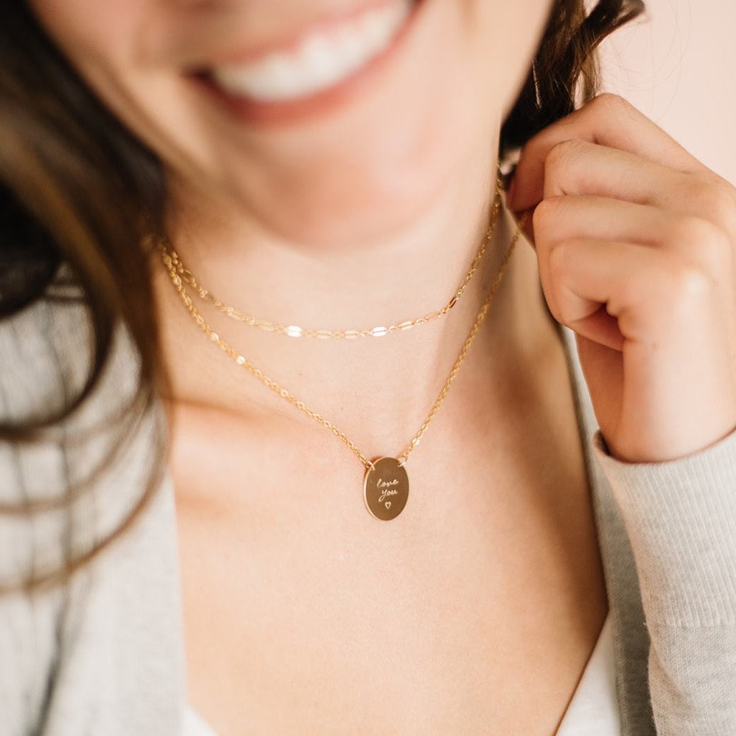 Woman wearing handmade gold choker and handmade gold custom engraved necklace